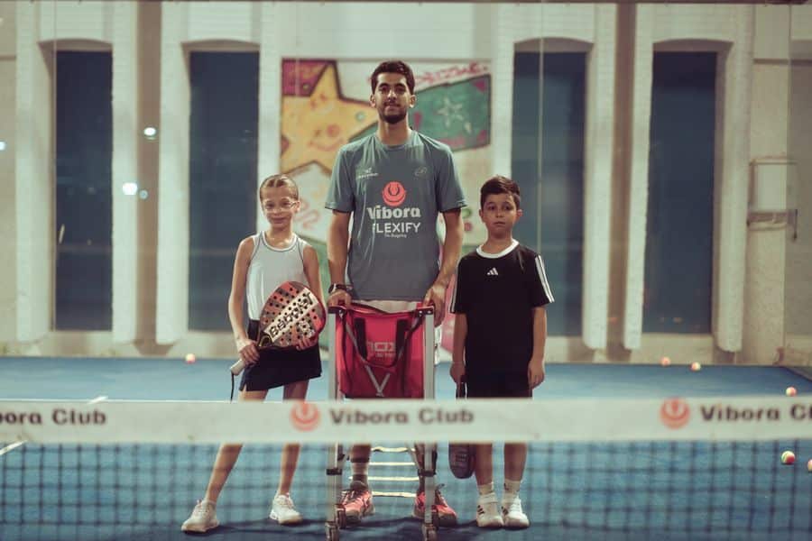 Entrenador de tenis con jugadores jóvenes